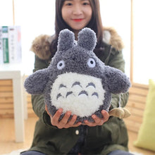 Totoro-style plush pillow toy held indoors for everyday cuddling and playroom use.