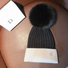 Two tone black knit pom pom beanie showing its warm knit body for cold weather comfort on kids outings.