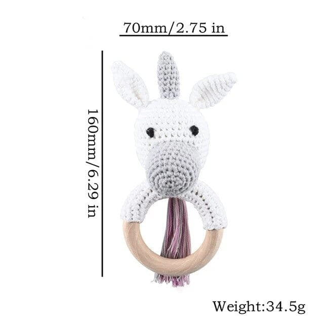White unicorn crochet baby rattle and teether wooden ring, a playful nursery toy for infants and baby showers.
