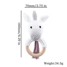 White unicorn crochet baby rattle and teether wooden ring, a playful nursery toy for infants and baby showers.