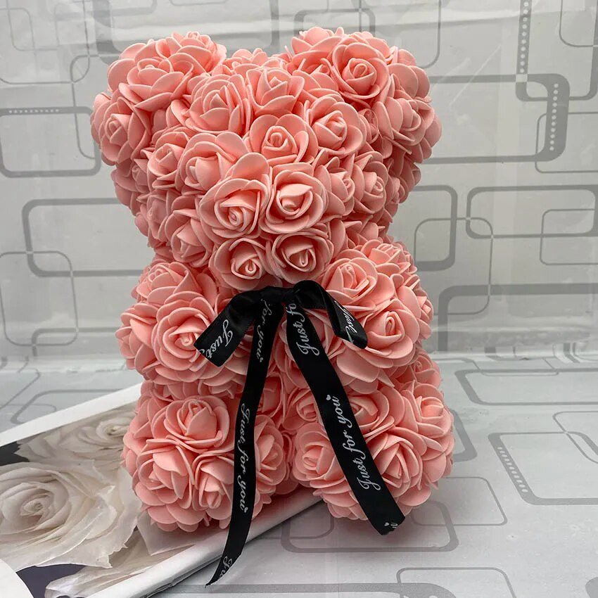 Pink teddy bear made of roses with a black ribbon
