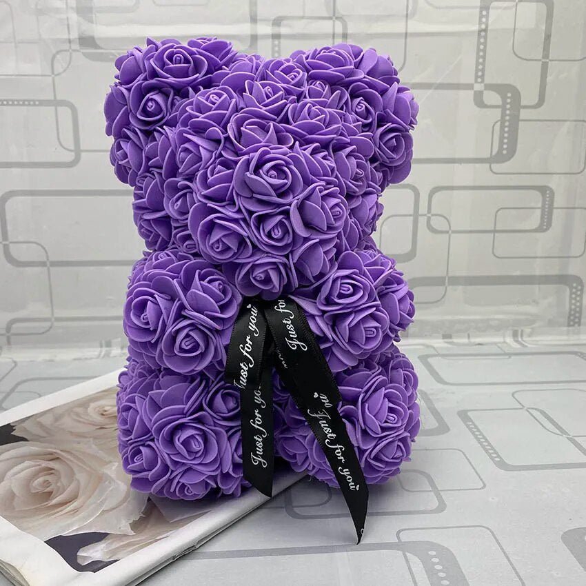 Purple teddy bear made of roses with a black ribbon.