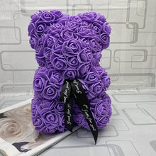 Purple teddy bear made of roses with a black ribbon.