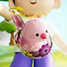 Pink water bird whistle with a cord held in front of a child in purple pants