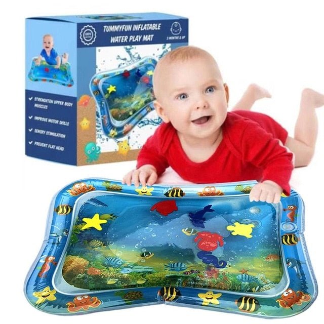 Baby playing with an inflatable water play mat featuring ocean designs, with a box in the background.