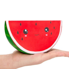 Watermelon squishy plush in hand for soothing squeeze play during travel and quiet time.