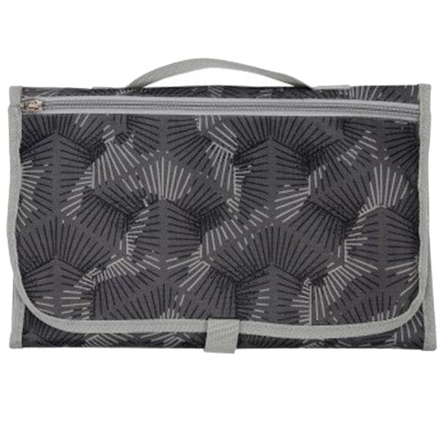 Waterproof baby changing mat folded in geometric fabric for travel days, holidays, and nursery drop-offs.