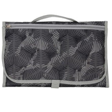 Waterproof baby changing mat folded in geometric fabric for travel days, holidays, and nursery drop-offs.