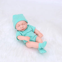 Baby doll in teal outfit with matching hat and socks on a white background
