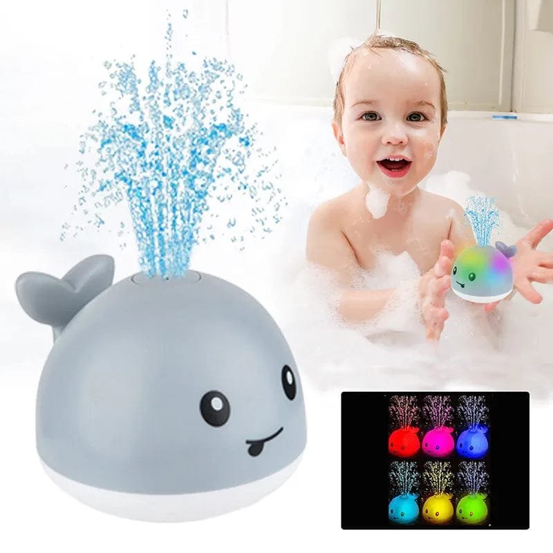 Baby bath toy shaped like a whale with water sprays and a colorful light-up display, next to a child in a bathtub.
