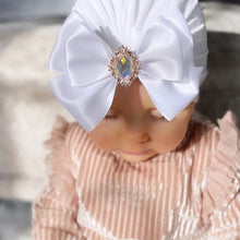 White bowknot baby turban with rhinestone brooch for christenings, family photos, and special occasion outfits.