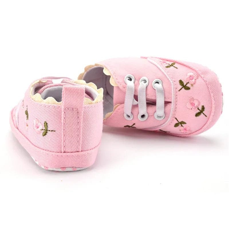 Top-down view of the white lace floral baby girl crib shoes, comfortable prewalkers for indoor wear and nursery time.