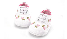 Flexible sole bend of the white lace floral baby shoes, showing the soft build that supports natural foot movement.