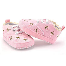 Pair of white lace floral newborn girl shoes laid flat, soft prewalkers for baby showers and christening gift sets.
