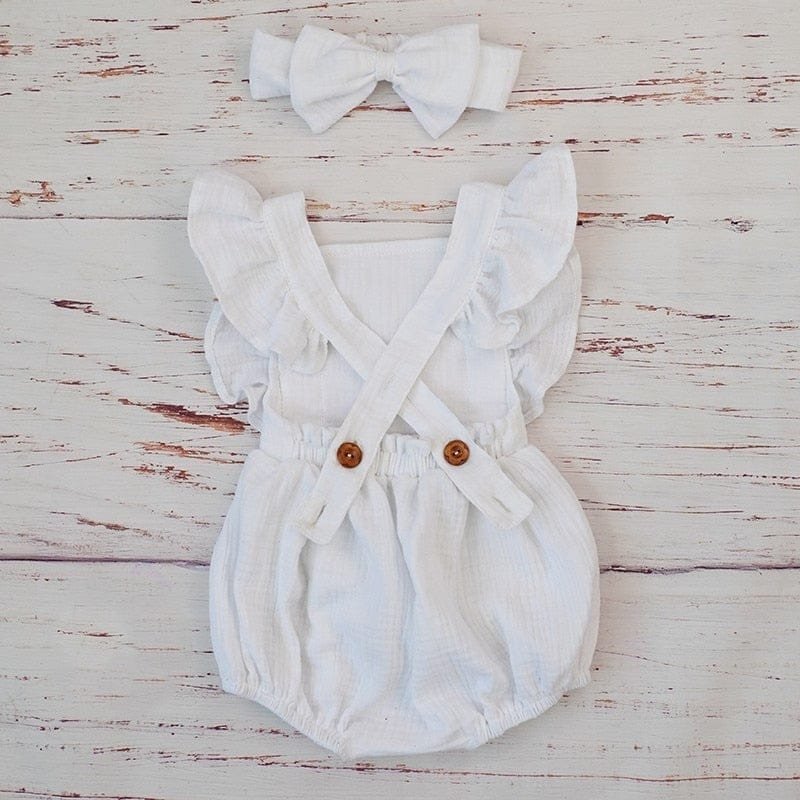 Close-up of the white organic cotton baby romper buttons and ruffles that make dressing and nappy changes easier.