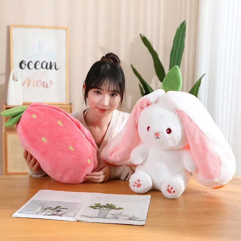 White carrot rabbit plush toy lifted out of its strawberry bag pillow for cuddle play and bedtime comfort.