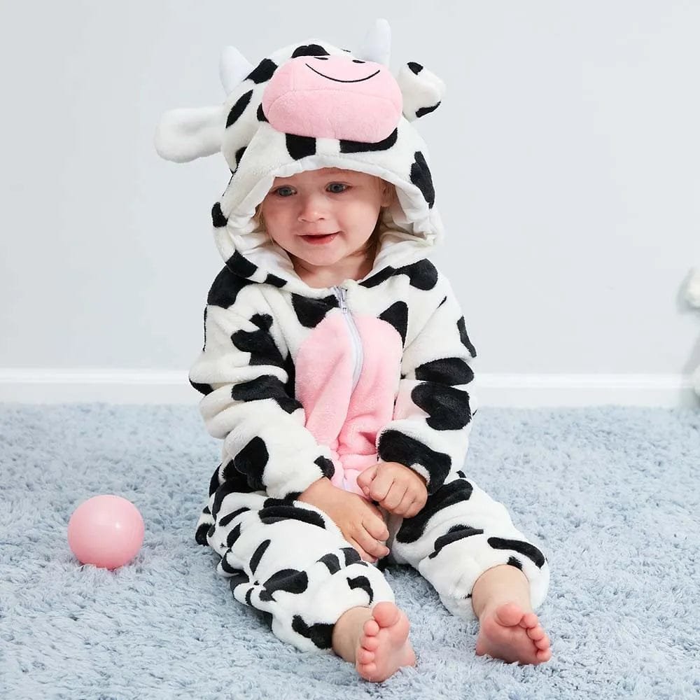 Cow winter flannel romper child on a blue carpet in a third photo showing the hooded animal design.