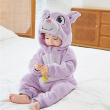 Child in the purple animal winter flannel romper seated on a bed, a hooded onesie for bedtime and lazy weekends.