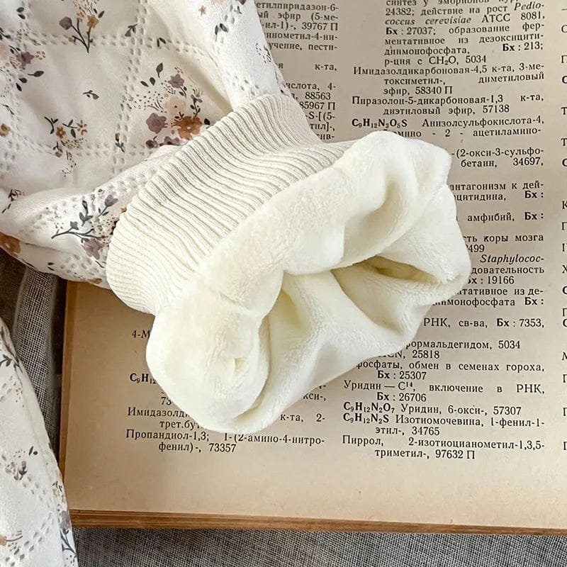 Close-up of the knitted bow trim on the winter floral romper set, a soft finishing touch for baby photos and outings.