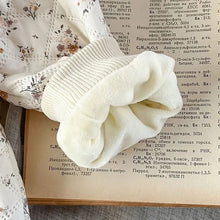 Close-up of the knitted bow trim on the winter floral romper set, a soft finishing touch for baby photos and outings.