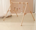 Wooden baby activity gym with hanging rattle toys for tummy time, reaching practice and nursery play.