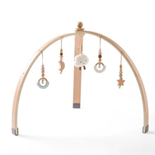 Wooden baby arch with hanging toys.
