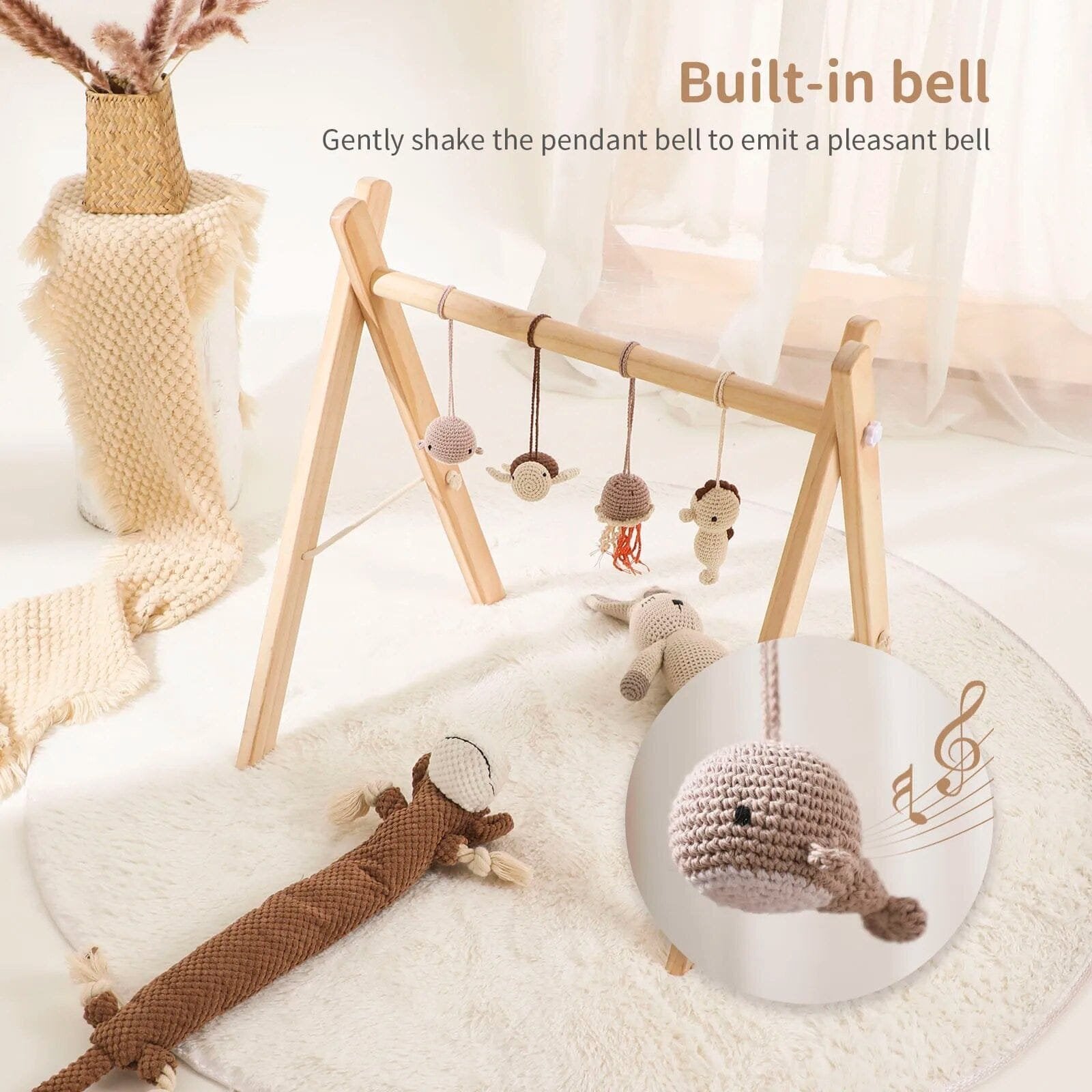 Wooden baby play gym with hanging toys over a soft mat, supporting tummy time and early reaching practice.