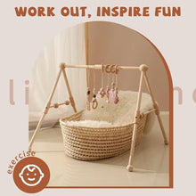 Wooden baby play gym set over a soft mat for floor time, kicking practice and quiet play.