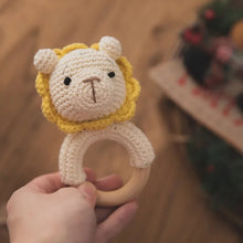 Natural wood grain detail of the baby rattle and teether ring, a smooth chewable toy for infants during teething months.