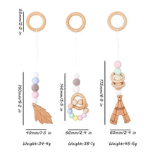 Wooden baby teether with size detail for hanging on the activity gym during teething and play.