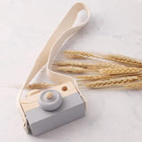 Wooden toy camera with a strap and wheat.