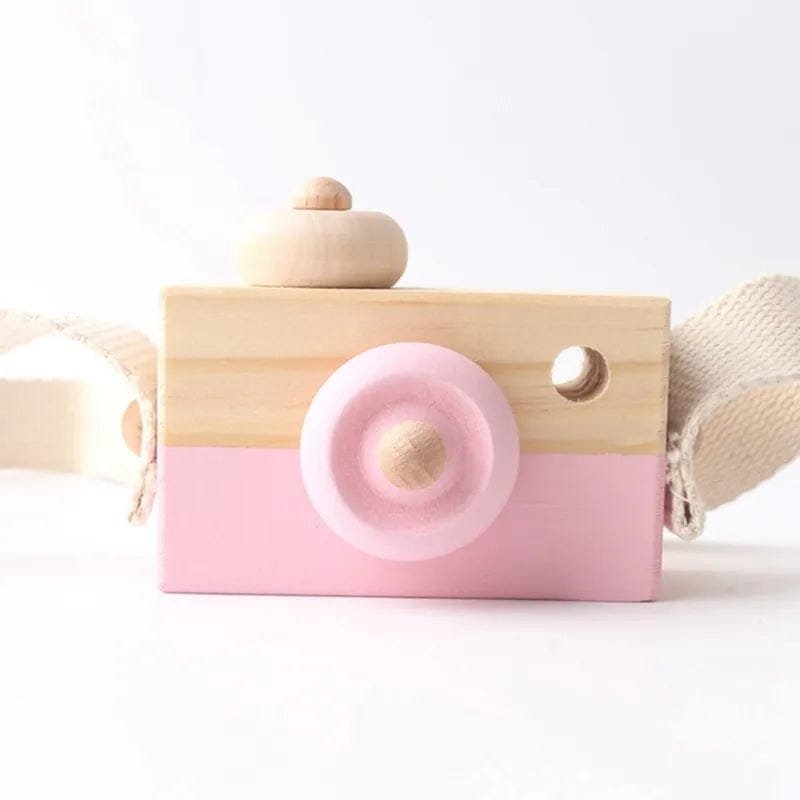 Wooden toy camera with pink lens.