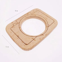Handmade wooden camera pendant lens cutout with dimensions, a DIY Montessori gift kids can decorate and play with.
