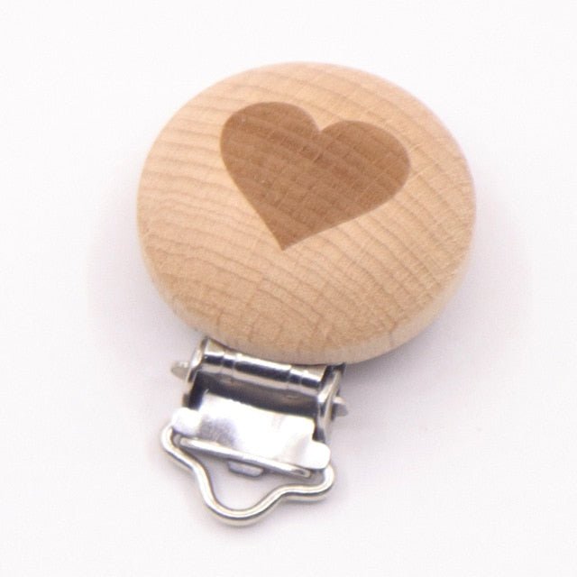 Wooden pacifier clip with a heart design, a smooth teether holder that keeps soothers clean during outings.