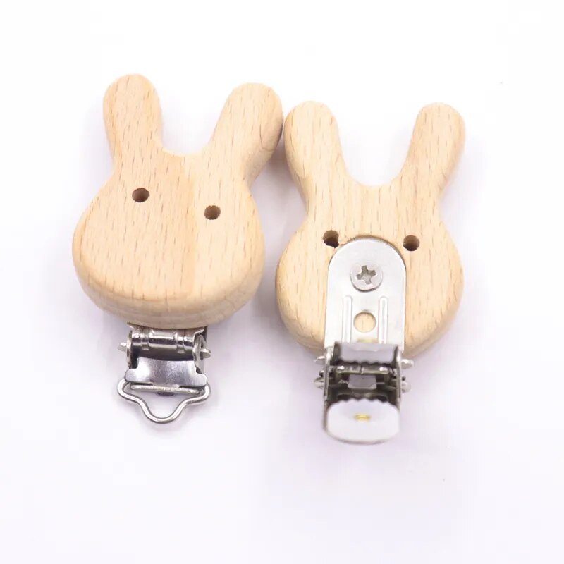 Pair of wooden rabbit pacifier clips with metal clasps, beech teether holders for newborn soothing and nappy bag storage.