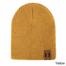 Yellow knitted baby beanie with leather patch for kids winter dressing and bright cold-weather outfits.