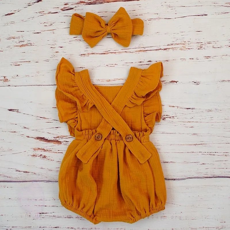 Yellow ruffle romper and headband set laid flat, breathable organic cotton for baby naps, play, and summer days.