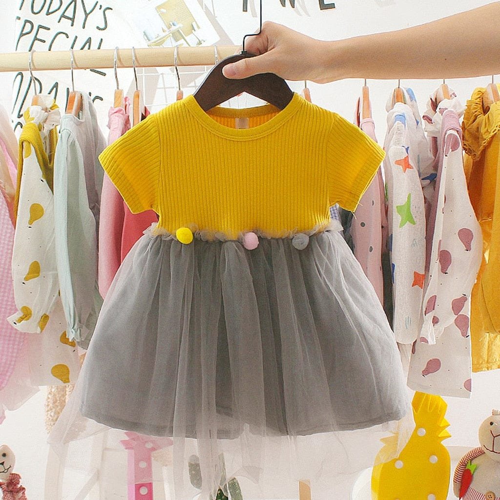 Yellow top and grey tulle skirt girls dress on a hanger for casual wear, nursery days, and family outings.